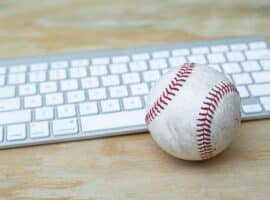 Baseball And Keyboard On A Wooden Desk