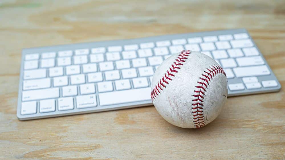 Baseball And Keyboard On A Wooden Desk