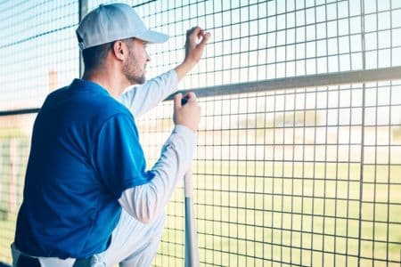 assistant baseball coach observing game from dugout