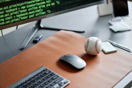Baseball And Mouse Next To Coding Screen