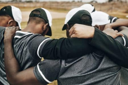 baseball team unity huddle with assistant coach