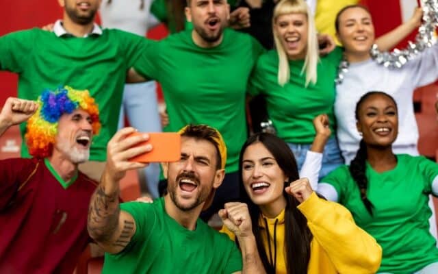 sports fans creating content and celebrating team community at game