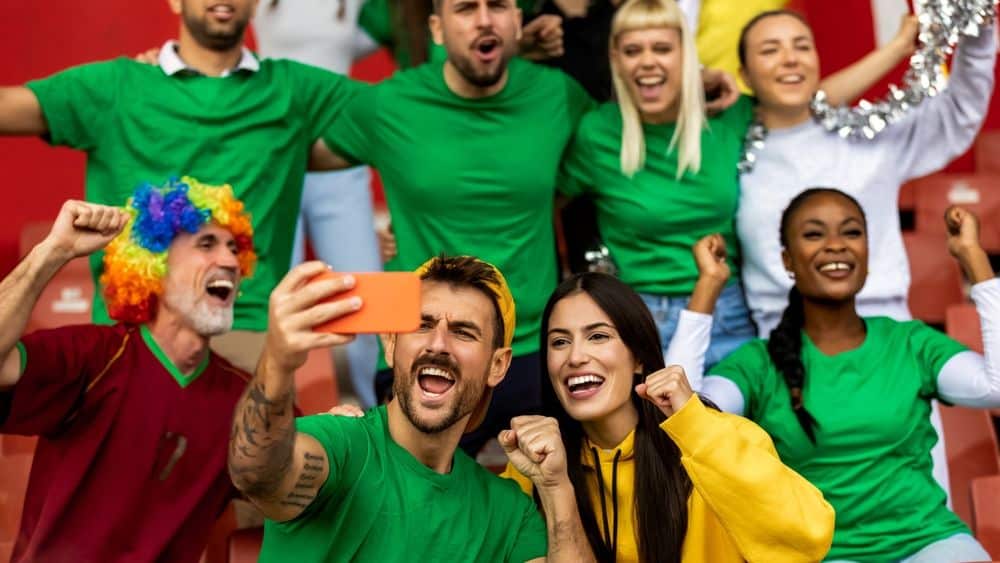 sports fans creating content and celebrating team community at game
