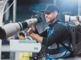 sports photographer capturing live game action with a professional telephoto lens