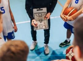 basketball coach drawing plays during a team strategy huddle