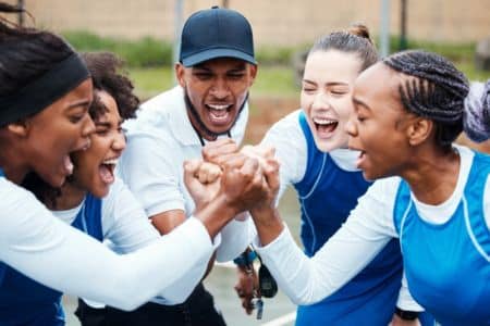 college coach motivating student-athletes during a team huddle session