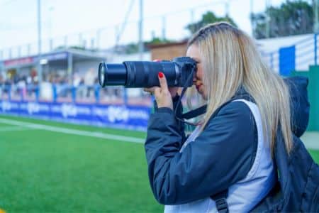 sideline photographer documenting athletes during a live sporting event