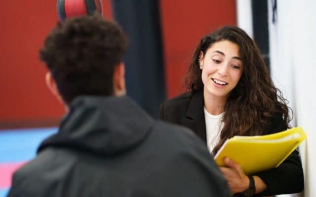 sports social worker meeting one-on-one with a young athlete for support.